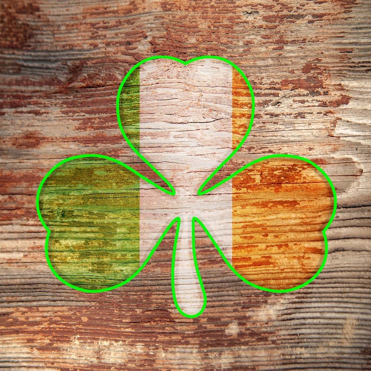 Foto el día de san patricio, el trébol de color de la bandera irlandesa con borde verde se dibuja sobre una vieja superficie de madera en mal estado