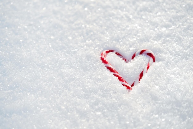 Día de san valentín amor banner web romántico con corazón de caramelo rojo sobre fondo de día de san valentín de nieve blanca