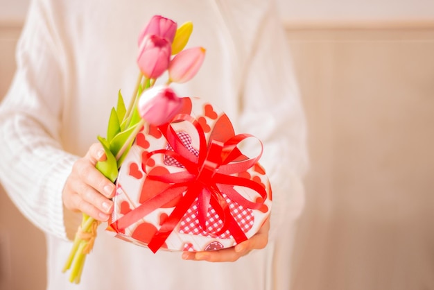 Día de San Valentín cardarms con caja de regalo con flores bowand en forma de corazón Mano dar regalo con flores