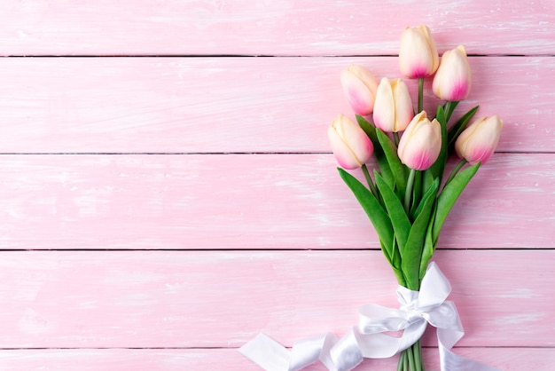 Día de San Valentín y el concepto de amor. Tulipanes rosados en fondo de madera.