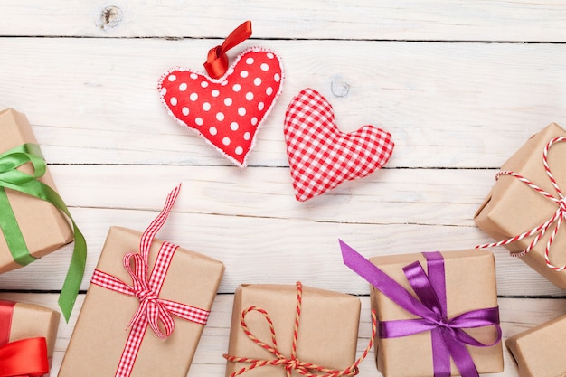 Día de San Valentín corazones de juguete y cajas de regalo sobre fondo de mesa de madera