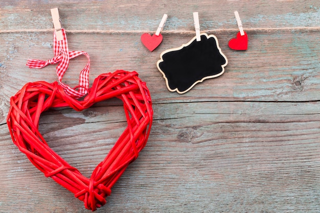 Día de San Valentín con corazones rojos y una pizarra en tablones de madera.