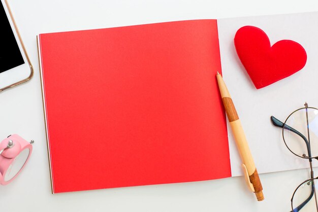 Día de San Valentín y Día más dulce, amor y concepto rojo. Copie espacio para texto con notebook y teléfono móvil