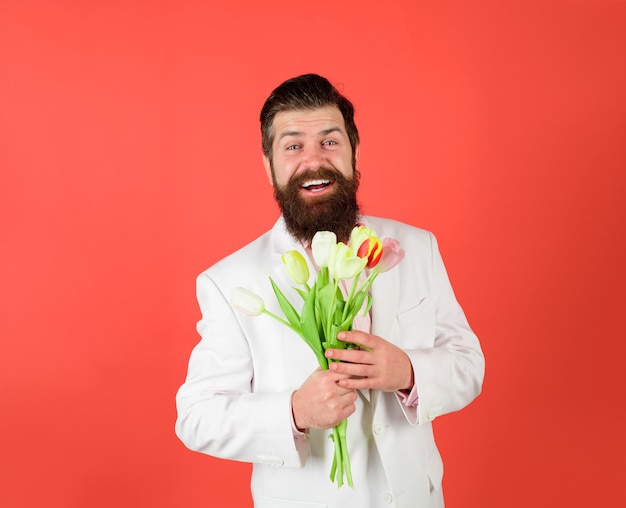 Día de san valentín día de la mujer cumpleaños hombre guapo flores empresario con ramo de tulipanes para