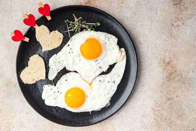 Día de san valentín huevo frito desayuno en la mesa huevos revueltos en forma de corazón decoración navideña amor