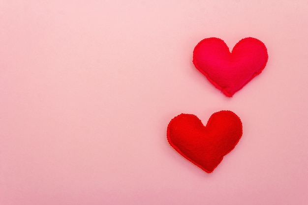 Día de San Valentín o concepto romántico de boda. Corazones rosados y rojos sobre fondo rosa, vista superior, espacio de copia, endecha plana