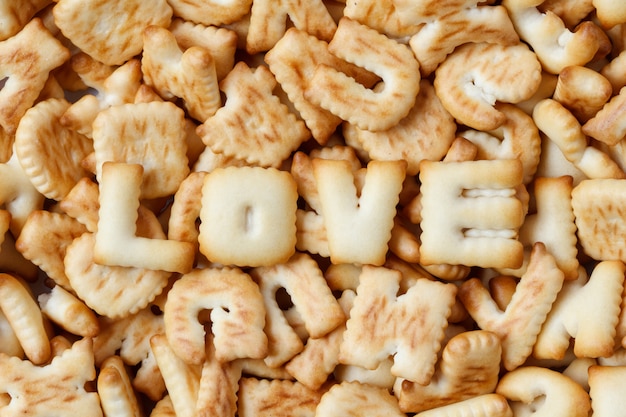 Día de San Valentín, palabra AMOR compuesta con letras de galletas dispuestas en madera