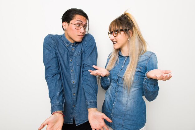 En el día de San Valentín Pareja joven con gafas haciendo un gesto sin importancia mientras levanta los hombros