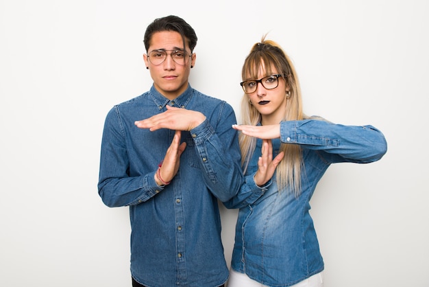 En el día de San Valentín Pareja joven con gafas haciendo gesto de parada con su mano para detener un acto