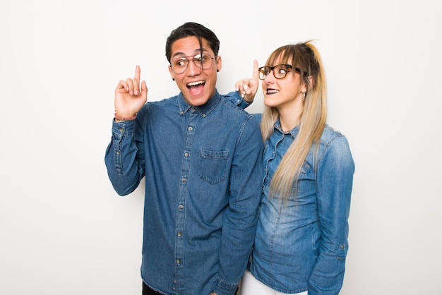 En el día de San Valentín Pareja joven con gafas con la intención de realizar la solución mientras levanta un dedo.