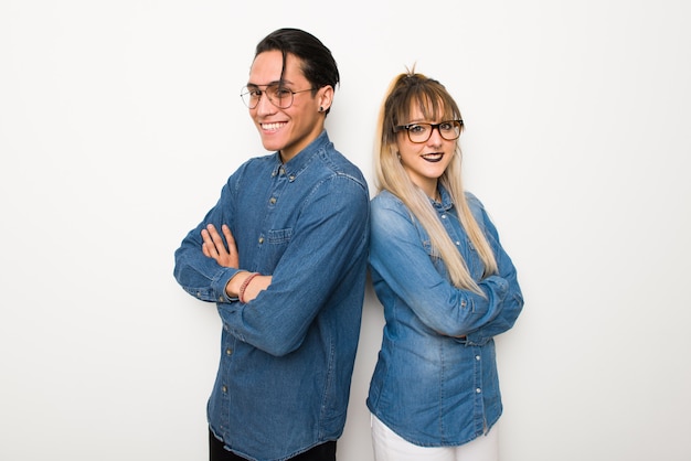 En el día de San Valentín Pareja joven con gafas manteniendo los brazos cruzados en posición lateral mientras sonríe