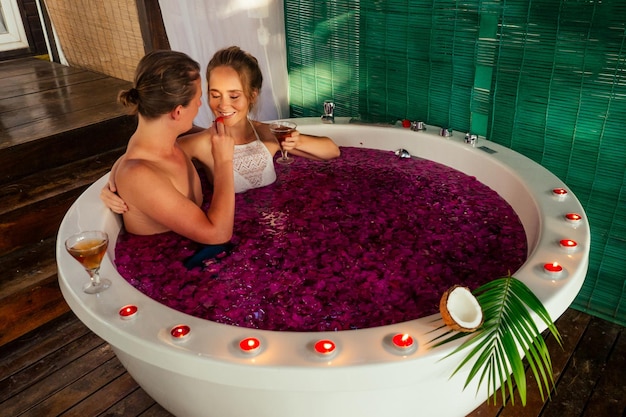 Día de San Valentín pareja joven tumbado en el baño romántico jacuzzi en luna de miel