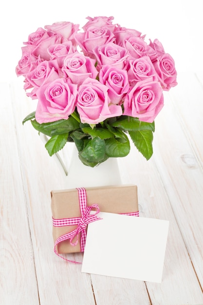 Día de San Valentín ramo de rosas rosadas y caja de regalo en mesa de madera blanca