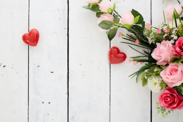 Día de San Valentín romántico corazón rojo y ramo de flores de colores en la mesa de madera blanca
