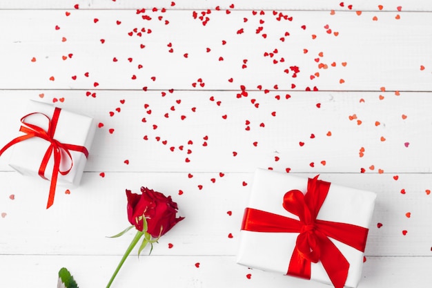 Día de San Valentín. Rosas rojas y caja de regalo en mesa de madera