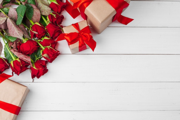 Día de San Valentín. Rosas rojas y caja de regalo en mesa de madera