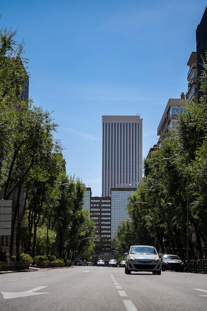 Día soleado en el centro de la ciudad de Madrid con edificios comerciales y coches al fondo