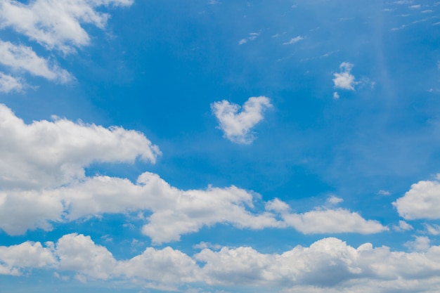 Día soleado con nubes mullidas blancas en el cielo azul