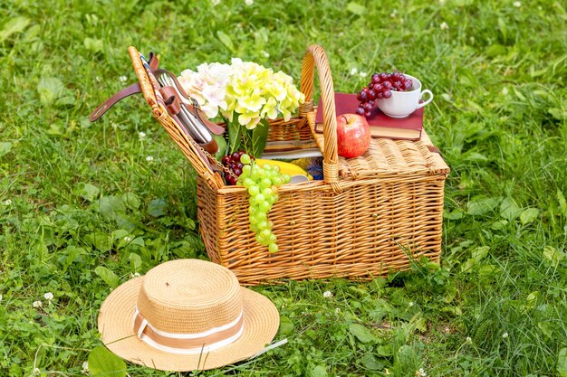 Día soleado de verano y almuerzo de canasta de picnic en el parque sobre la hierba verde