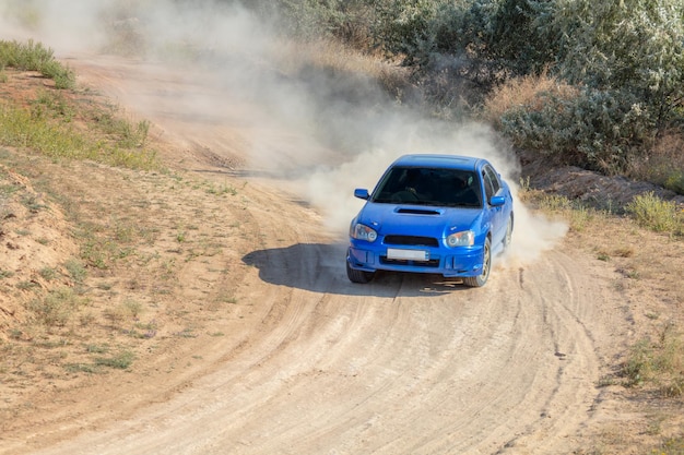 Día soleado de verano Pista de rally polvorienta Un coche de rally genera mucho polvo en la curva 12