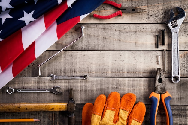 Día del trabajo, bandera de los Estados Unidos de América con muchas herramientas útiles en madera
