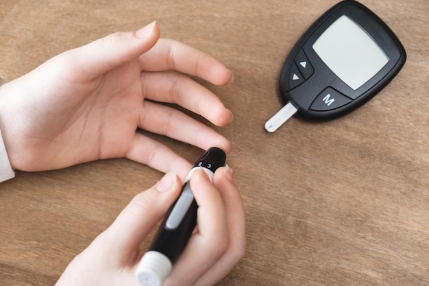 Diabetes, der den Blutzuckerspiegel überprüft. Kind mit Lanzette und Blutzuckermessgerät zu Hause