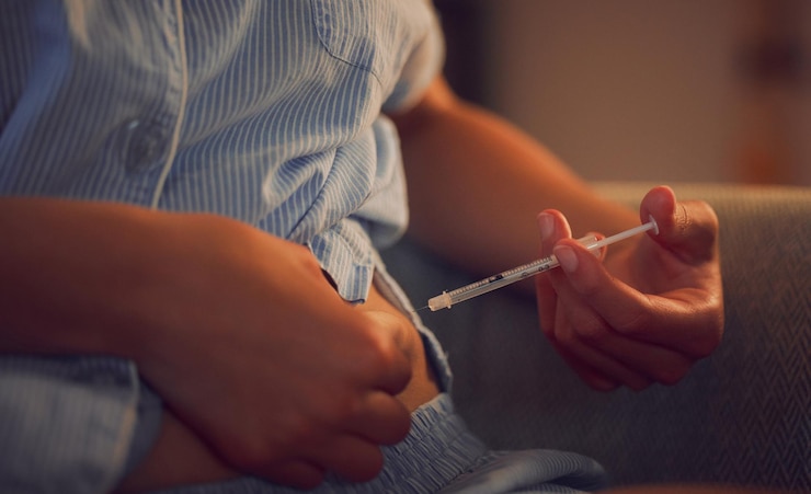 Foto diabetes diabético e injeção de insulina de uma mulher com doença crônica tarde da noite mãos de uma mulher tomando sua dose diária de tratamento com uma seringa à noite em casa