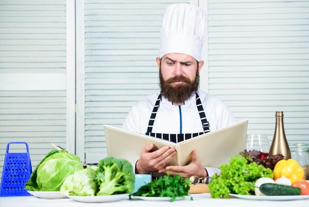 Diät Bio-Lebensmittel Gesundes Essen Kochen Reifer Hipster mit Bart Küche kulinarisch Vitamin Vegetarischer Salat mit frischem Gemüse Ernster bärtiger Mann Kochrezept Zubereitung gesunder Lebensmittel