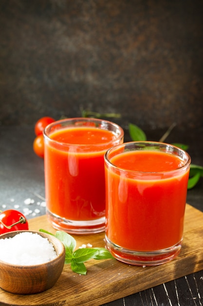 Diät-Ernährungskonzept Gläser mit Tomatensaft und frischen Tomaten auf einem Steintisch