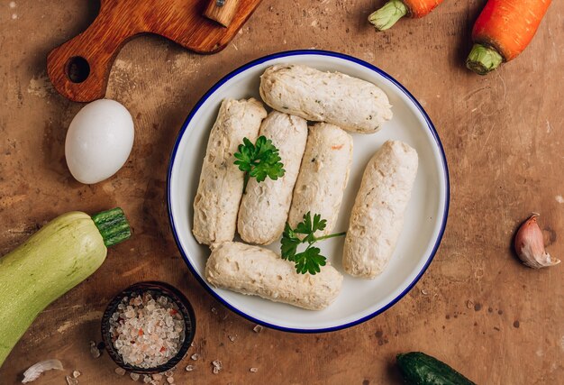 Diät-gesundes Lebensmittelkonzept. Gekochte hausgemachte Hühnerwurst auf braunem Hintergrund. Ansicht von oben