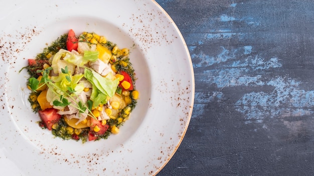 Diät-Salat mit Hähnchenfilet, Mais, Tomaten und gebackenem Kürbis. Draufsicht. Speicherplatz kopieren