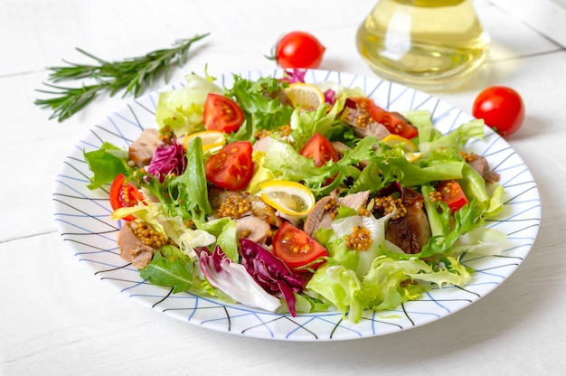 Diät-Salat mit Magre-Entenbrust, frischen Kräutern, Gemüse und Senfsauce auf hellem Holz