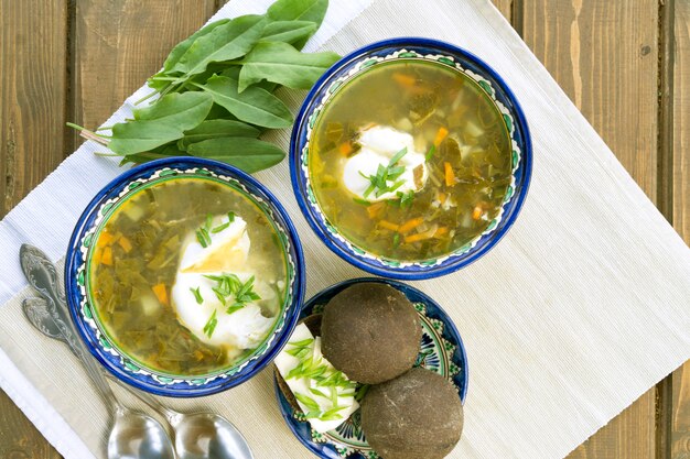 Diät-Sauerampfer-Suppe mit Ei. auf einem holztisch.