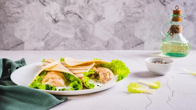 Foto diätetische gegrillte tacos mit hühnerfilet-salat auf einem teller auf dem tisch