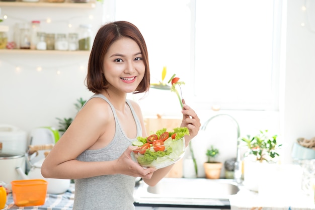 Diätkonzept. Gesundes Essen. Schöne junge asiatische Frau, die Frischgemüsesalat isst. Konzept zum Abnehmen