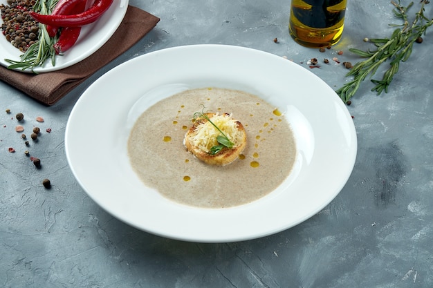 Diätpilzcremesuppe mit Croutons mit Käse in einem weißen Teller