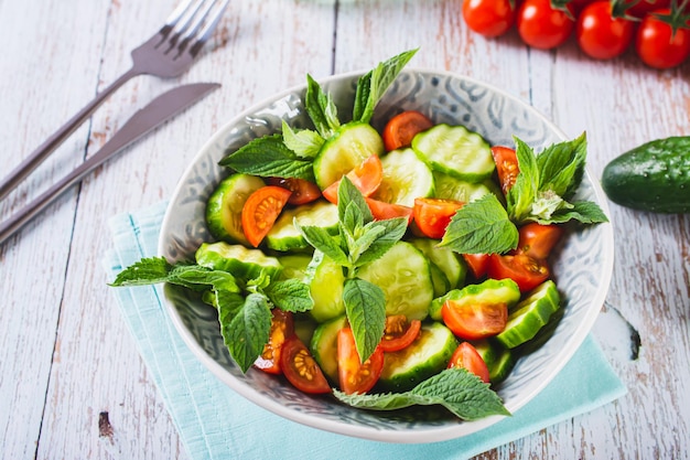 Diätsalat aus Gurken, Tomaten und Minze in einer Schüssel auf dem Tisch