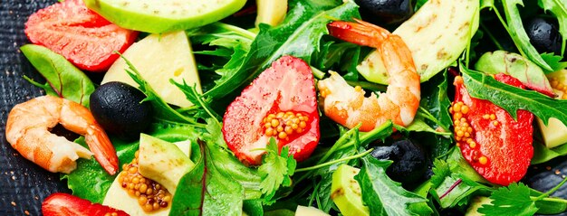 Diätsalat mit Garnelen, Erdbeeren, Avocado und Kräutern. Lebensmittelhintergrund, langes Banner