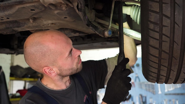 Diagnóstico de automóviles, un mecánico de automóviles inspecciona un taller de reparación de automóviles que rompe la transmisión