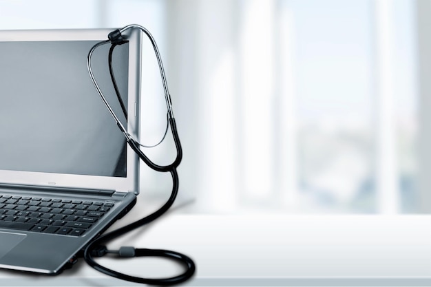 Diagnóstico de laptop com estetoscópio no fundo