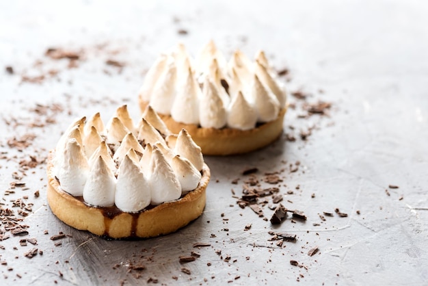 Diagonal de duas deliciosas tortinhas com merengue e creme de limão no fundo