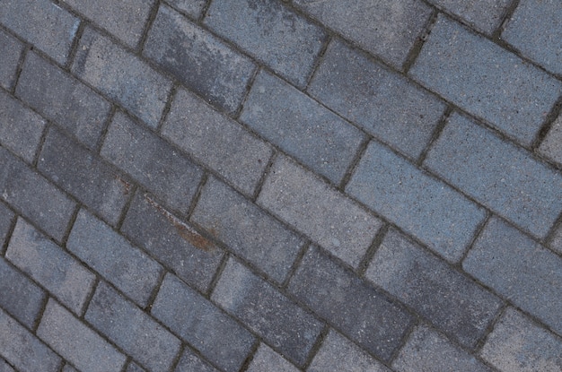 Diagonale Ansicht an verwitterter grauer Steinmauerstein des Schmutzes mit dunklen Zementgitterlinien