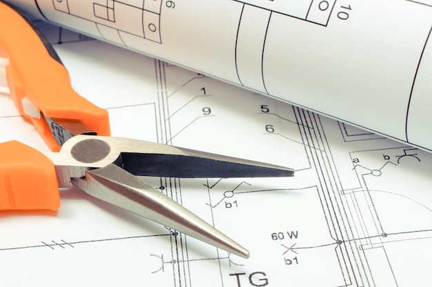 Diagramas elétricos e alicates no desenho de construção da casa Conceito de construção de casa