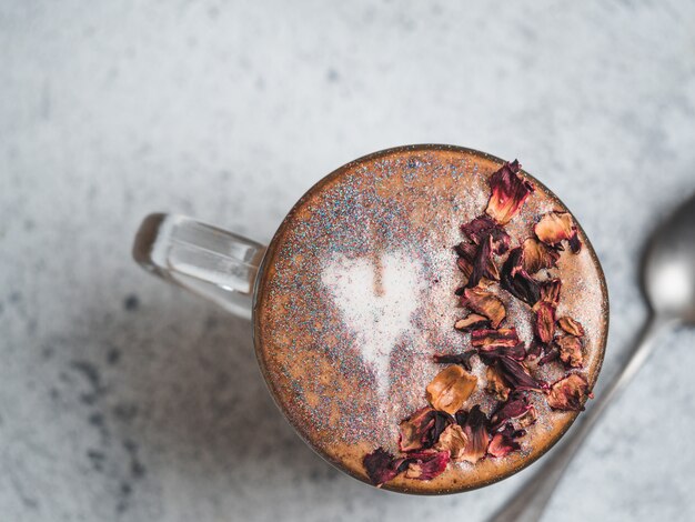 Diamantcappuccinokaffee mit den getrockneten rosafarbenen Blumenblättern