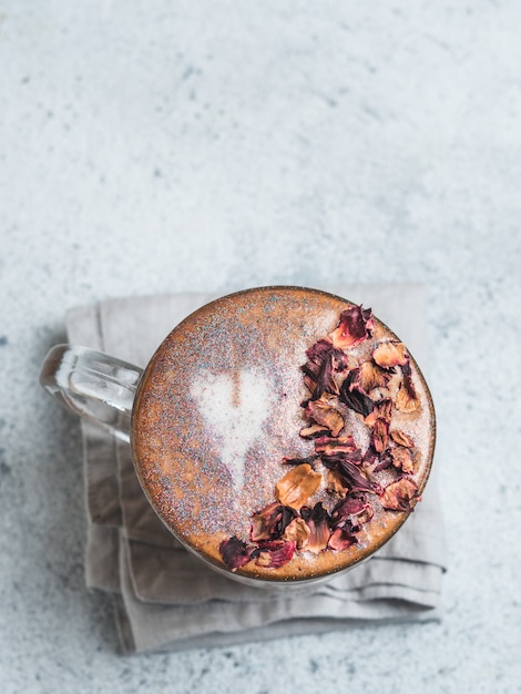 Diamantcappuccinokaffee mit den getrockneten rosafarbenen Blumenblättern