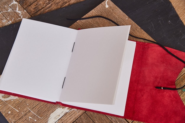 Diario de cuaderno de bocetos abierto en blanco con cuero rojo