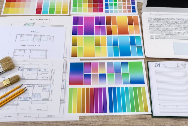 Diario con lápiz y muestra de color en el plan de la casa en la oficina