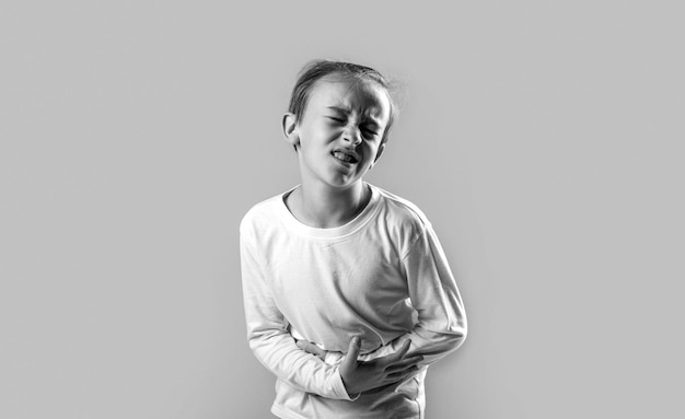 Diarréia ou gastroenterite problema de saúde Criança tem dor de estômago com intoxicação alimentar Criança segurando as mãos na barriga Preto e branco