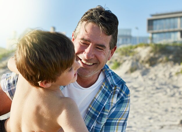 Los días de verano se pasan mejor con la familia en la playa Captura recortada de un padre y su hijo uniéndose en la playa