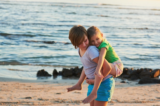 Los días de verano se pasan mejor en la playa Captura recortada de dos hermanos pequeños disfrutando el día juntos en la playa